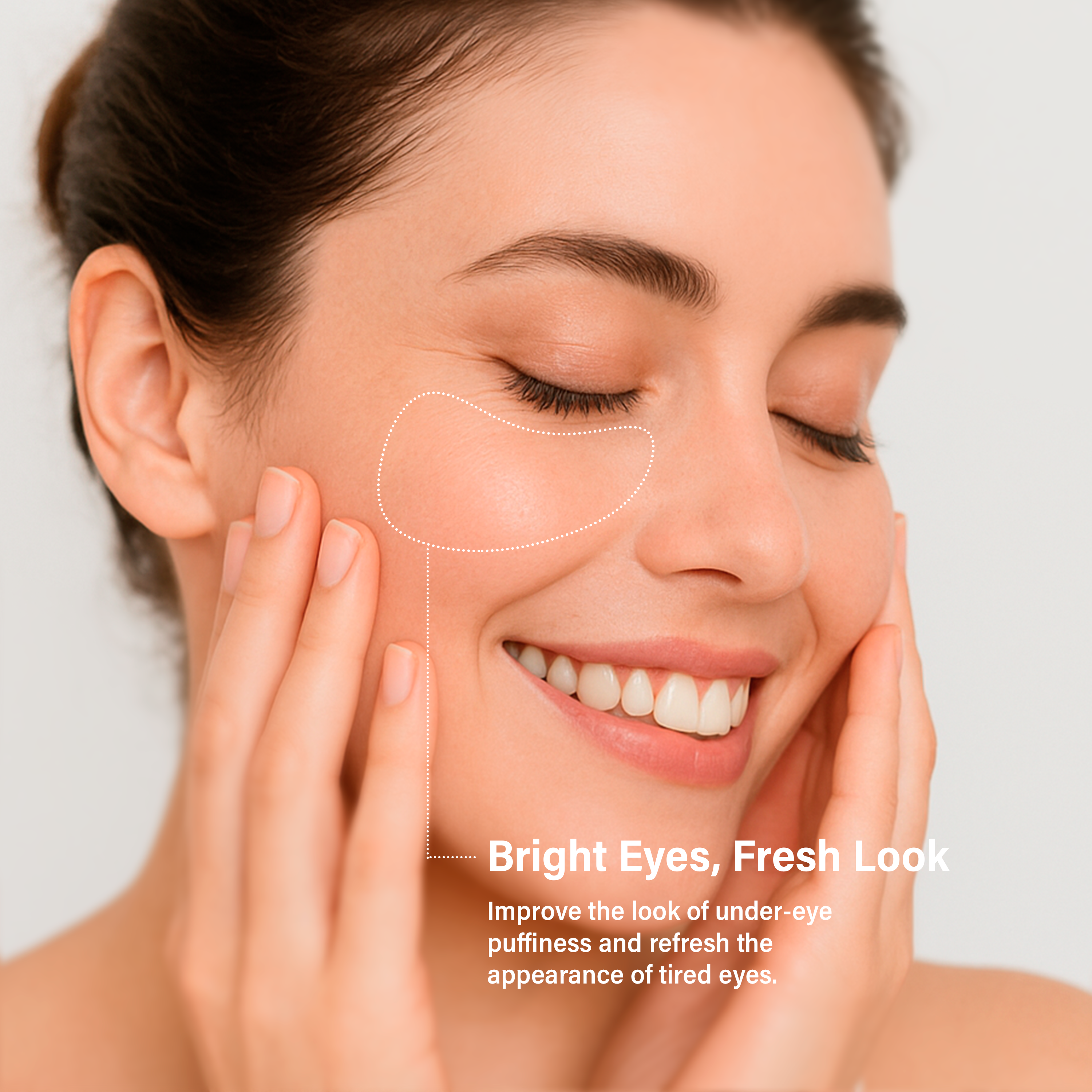 Close-up of a smiling woman with closed eyes gently touching her face, showing smooth skin and long lashes, with a highlighted area under the eye to suggest lunelle skincare focus, against a white background.